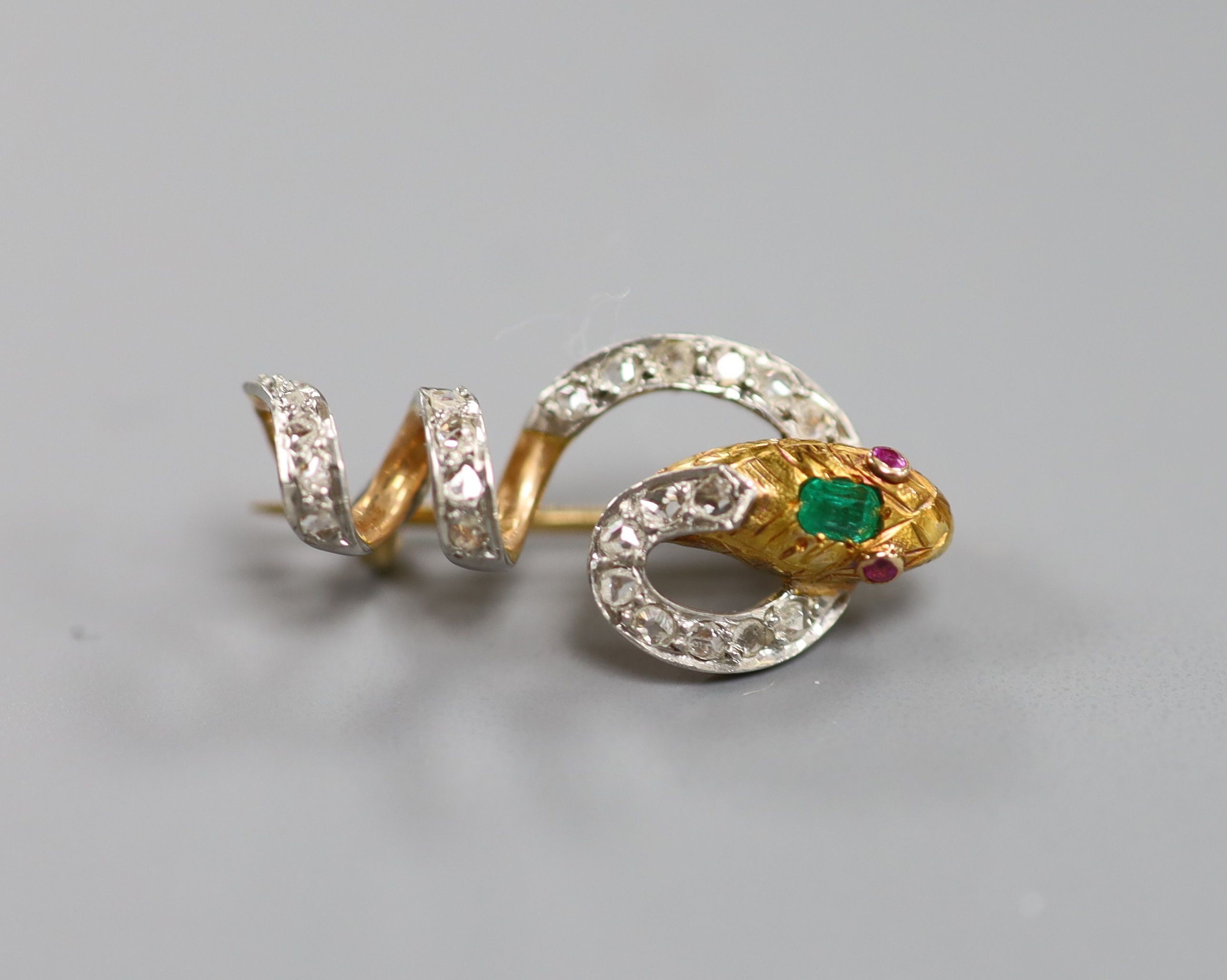 A Victorian yellow metal, emerald, ruby and rose cut diamond set serpent brooch, 25mm, gross weight 3.5 grams